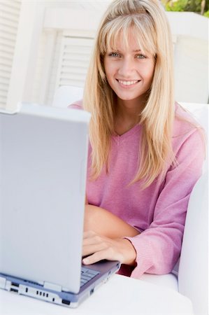 Woman on patio using laptop smiling Photographie de stock - Aubaine LD & Abonnement, Code: 400-04045130