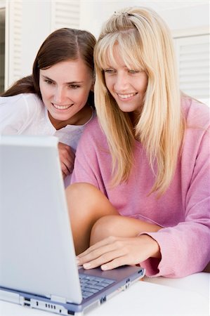 Two women on patio using laptop smiling Photographie de stock - Aubaine LD & Abonnement, Code: 400-04045131