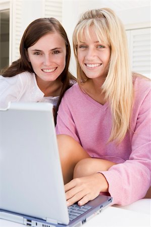 Two women on patio using laptop smiling Photographie de stock - Aubaine LD & Abonnement, Code: 400-04045132