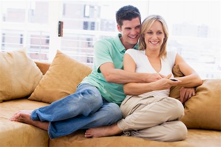 simsearch:400-04045202,k - Couple in living room with remote control smiling Stock Photo - Budget Royalty-Free & Subscription, Code: 400-04045149