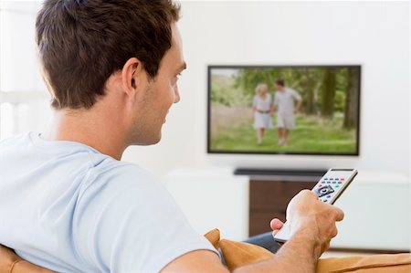 Man in living room watching television Stock Photo - Budget Royalty-Free & Subscription, Code: 400-04045160
