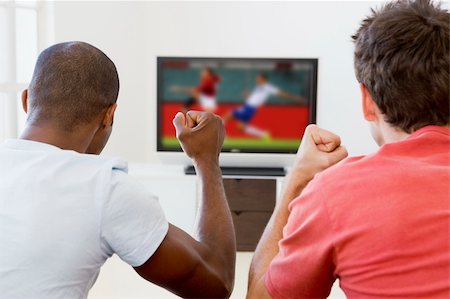 Two men in living room watching television and cheering Stock Photo - Budget Royalty-Free & Subscription, Code: 400-04045173