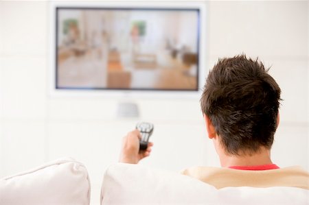 Man in living room watching television Stock Photo - Budget Royalty-Free & Subscription, Code: 400-04045199