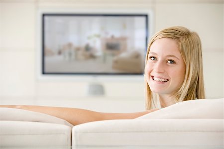 Woman in living room watching television smiling Stock Photo - Budget Royalty-Free & Subscription, Code: 400-04045206