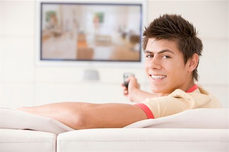 Man in living room watching television smiling Stock Photo - Budget Royalty-Free & Subscription, Code: 400-04045200