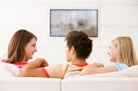 simsearch:400-04045202,k - Three friends in living room watching television smiling Stock Photo - Budget Royalty-Free & Subscription, Code: 400-04045220