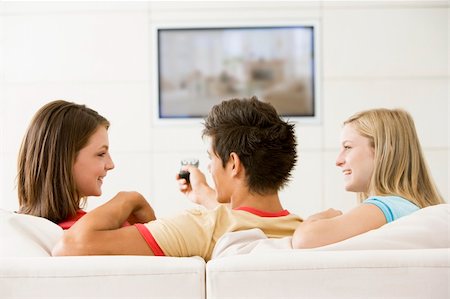 simsearch:400-04045202,k - Three friends in living room watching television smiling Stock Photo - Budget Royalty-Free & Subscription, Code: 400-04045221