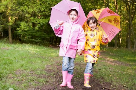 Two sisters outdoors with umbrellas smiling Stock Photo - Budget Royalty-Free & Subscription, Code: 400-04045367