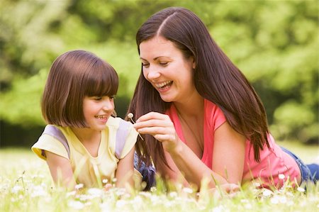 simsearch:400-04046012,k - Mother and daughter lying outdoors with flower smiling Stockbilder - Microstock & Abonnement, Bildnummer: 400-04045407