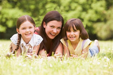 simsearch:400-04046012,k - Mother and daughters lying outdoors with flower smiling Stockbilder - Microstock & Abonnement, Bildnummer: 400-04045412
