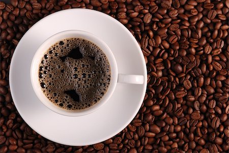 simsearch:400-04305840,k - Cup of coffee. A background with coffee grains and a white cup. A photo close up Foto de stock - Super Valor sin royalties y Suscripción, Código: 400-04045495