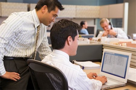 Two businessmen in cubicle looking at laptop Stock Photo - Budget Royalty-Free & Subscription, Code: 400-04045589
