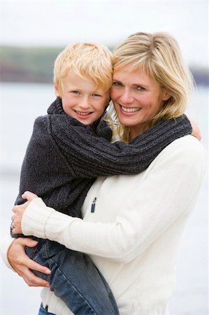 simsearch:400-05686748,k - Mother holding son at beach smiling Fotografie stock - Microstock e Abbonamento, Codice: 400-04045668