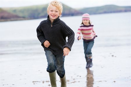 Two young children running on beach smiling Stock Photo - Budget Royalty-Free & Subscription, Code: 400-04045678
