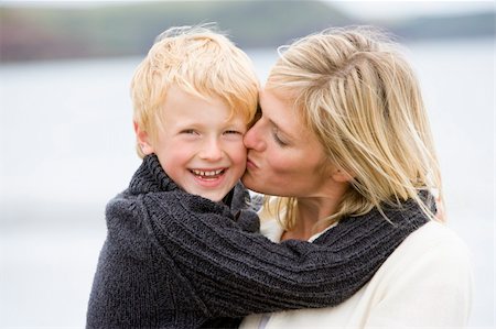 simsearch:400-05686748,k - Mother kissing son at beach smiling Fotografie stock - Microstock e Abbonamento, Codice: 400-04045670