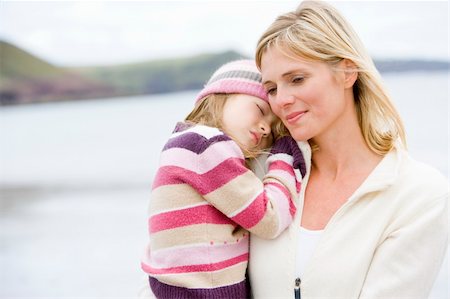 simsearch:400-05686748,k - Mother holding sleeping daughter at beach Fotografie stock - Microstock e Abbonamento, Codice: 400-04045673