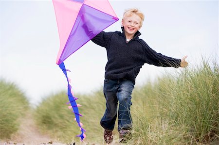 Young boy running on beach with kite smiling Stock Photo - Budget Royalty-Free & Subscription, Code: 400-04045687