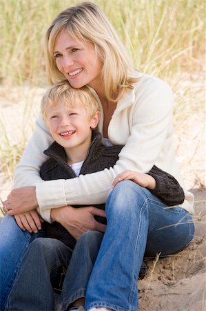 simsearch:400-05686748,k - Mother and son sitting on beach smiling Fotografie stock - Microstock e Abbonamento, Codice: 400-04045696