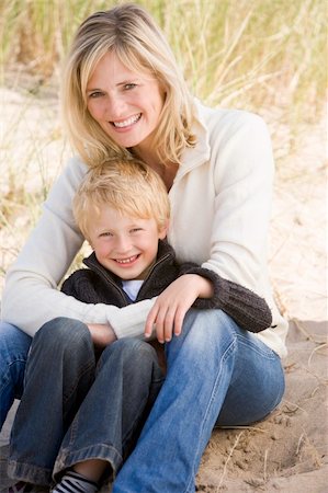 simsearch:400-05686748,k - Mother and son sitting on beach smiling Fotografie stock - Microstock e Abbonamento, Codice: 400-04045697