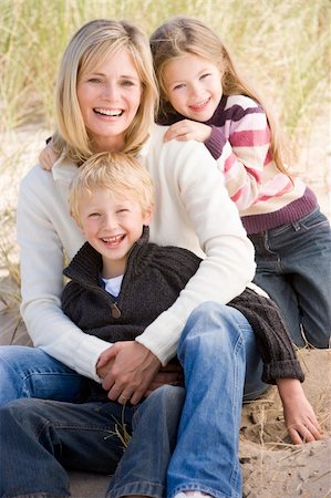 simsearch:400-05686748,k - Mother and two young children sitting on beach smiling Fotografie stock - Microstock e Abbonamento, Codice: 400-04045698