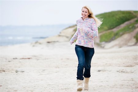 Woman running at beach smiling Stock Photo - Budget Royalty-Free & Subscription, Code: 400-04045778