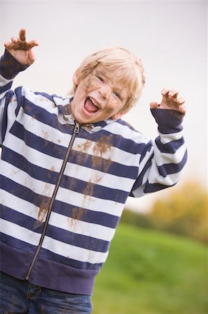 playing in mud - Young boy standing outdoors dirty and smiling Stock Photo - Budget Royalty-Free & Subscription, Code: 400-04045785