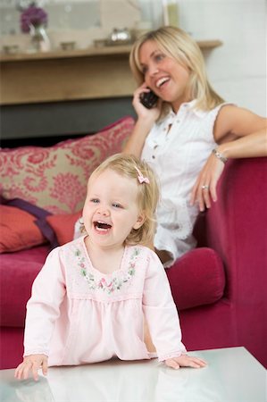 simsearch:400-04045907,k - Mother using telephone in living room with baby smiling Stock Photo - Budget Royalty-Free & Subscription, Code: 400-04045808