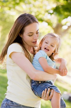 simsearch:400-05736759,k - Mother holding daughter outdoors smiling Stock Photo - Budget Royalty-Free & Subscription, Code: 400-04045918