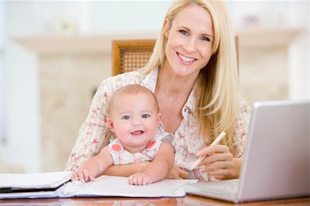 Mother and baby in dining room with laptop smiling Fotografie stock - Microstock e Abbonamento, Codice: 400-04045933