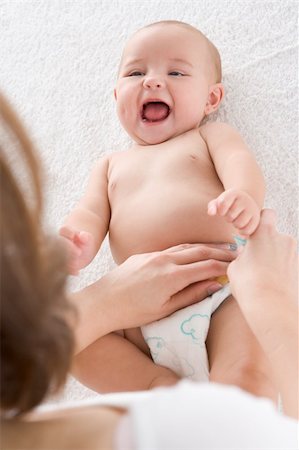 full body massage - Mother changing baby's diaper indoors Foto de stock - Super Valor sin royalties y Suscripción, Código: 400-04045942