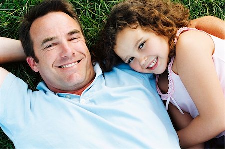 simsearch:400-04042848,k - Father and daughter lying outdoors smiling Fotografie stock - Microstock e Abbonamento, Codice: 400-04046011