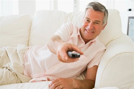 simsearch:400-04046300,k - Man in living room using remote control smiling Stock Photo - Budget Royalty-Free & Subscription, Code: 400-04046266