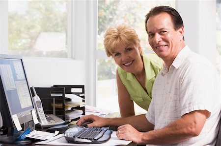 Couple in home office at computer smiling Stock Photo - Budget Royalty-Free & Subscription, Code: 400-04046273