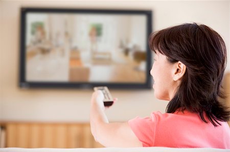 simsearch:400-04045202,k - Woman watching television using remote control Stock Photo - Budget Royalty-Free & Subscription, Code: 400-04046303