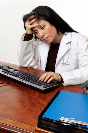 simsearch:400-04058980,k - Tired or stressed doctor with head in hands sitting at computer. Stock Photo - Budget Royalty-Free & Subscription, Code: 400-04047320