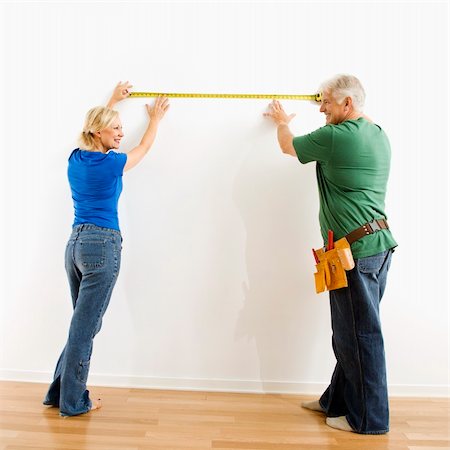 Middle-aged couple measuring wall with tape. Stock Photo - Budget Royalty-Free & Subscription, Code: 400-04040000