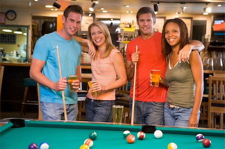 Two young couples standing beside a pool table in a bar Stock Photo - Budget Royalty-Free & Subscription, Code: 400-04040269