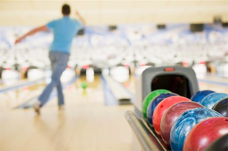 simsearch:700-00549132,k - Bowling ball machine with man bowling in the background Photographie de stock - Aubaine LD & Abonnement, Code: 400-04040261