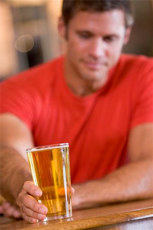 simsearch:400-05343153,k - Young man relaxing at a bar with a beer Fotografie stock - Microstock e Abbonamento, Codice: 400-04040293