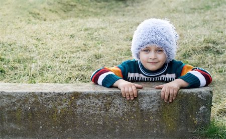 dundanim (artist) - Smiling playful kid with winter white hat on his head Fotografie stock - Microstock e Abbonamento, Codice: 400-04040454