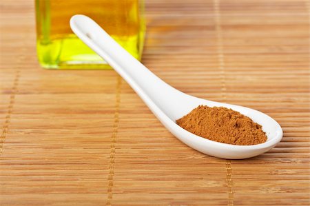 simsearch:400-03908268,k - Cinnamon in the spoon and oil bottle for prepare tasty food with soft shadow in the bamboo mat background. Shallow depth of field Photographie de stock - Aubaine LD & Abonnement, Code: 400-04041219
