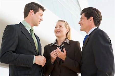 Three businesspeople standing outdoors by building talking and s Stock Photo - Budget Royalty-Free & Subscription, Code: 400-04041524