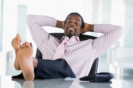 Businessman sitting in office with feet on desk relaxing and smi Stock Photo - Budget Royalty-Free & Subscription, Code: 400-04041573