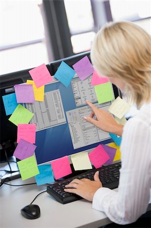 Businesswoman in office pointing at monitor with notes on it Stock Photo - Budget Royalty-Free & Subscription, Code: 400-04041692