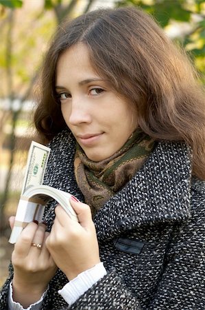 a young girl holding roll of dollars Foto de stock - Super Valor sin royalties y Suscripción, Código: 400-04041867