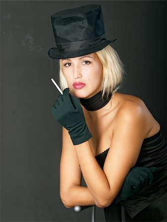 Young blonde woman in black hat keeps a cigarette and looks ahead. Photographie de stock - Aubaine LD & Abonnement, Code: 400-04042115