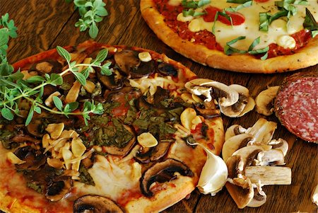 simsearch:400-04539943,k - Rustic mushroom and roasted garlic pizza on a vintage oak table Stockbilder - Microstock & Abonnement, Bildnummer: 400-04042588