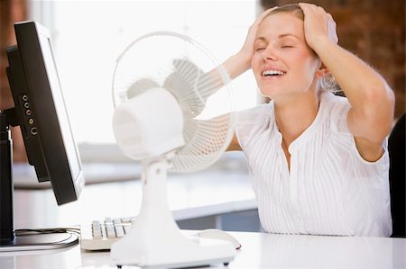 Businesswoman in office with computer and fan cooling off Stock Photo - Budget Royalty-Free & Subscription, Code: 400-04042674