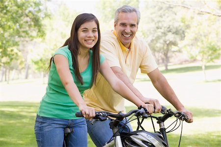 simsearch:400-04402106,k - Man and girl on bikes outdoors smiling Fotografie stock - Microstock e Abbonamento, Codice: 400-04042776