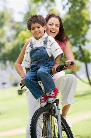 simsearch:400-04402100,k - Woman and young boy on a bike outdoors smiling Stock Photo - Budget Royalty-Free & Subscription, Code: 400-04042779